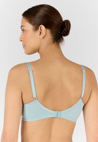 Soutien-gorge bleu clair avec des bretelles réglables, une texture lisse et une fermeture à agrafe. Conçu avec un dos minimaliste et des détails subtils.