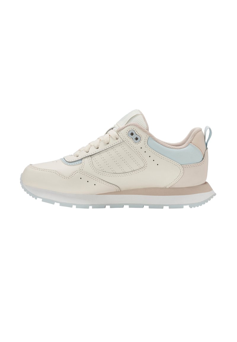 Zapatilla beige de perfil bajo con suela blanca, detalle en azul claro en el talón, collar acolchado y cierre de cordones, mostrada desde el lado externo.