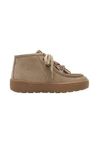 Chaussure à la cheville en daim marron clair avec une semelle épaisse en caoutchouc, lacets à l’avant et pompons décoratifs sur le côté, vue de l’extérieur.