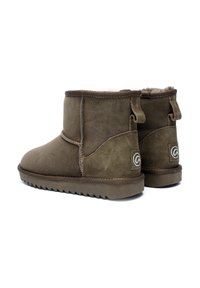 Botas de tobillo de ante marrón con un suave forro interior, punta redonda, tiradores en la parte trasera y suela de goma texturizada.