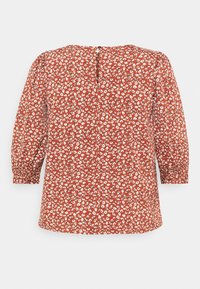 Blouse rouge rouille avec petit imprimé floral blanc, manches trois-quarts bouffantes et fermeture à boutons au dos.