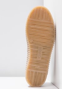 Semelle de chaussure avec des rainures texturées horizontales et verticales, de la marque "Gabor", fabriquée en Espagne, présentée sur fond blanc.