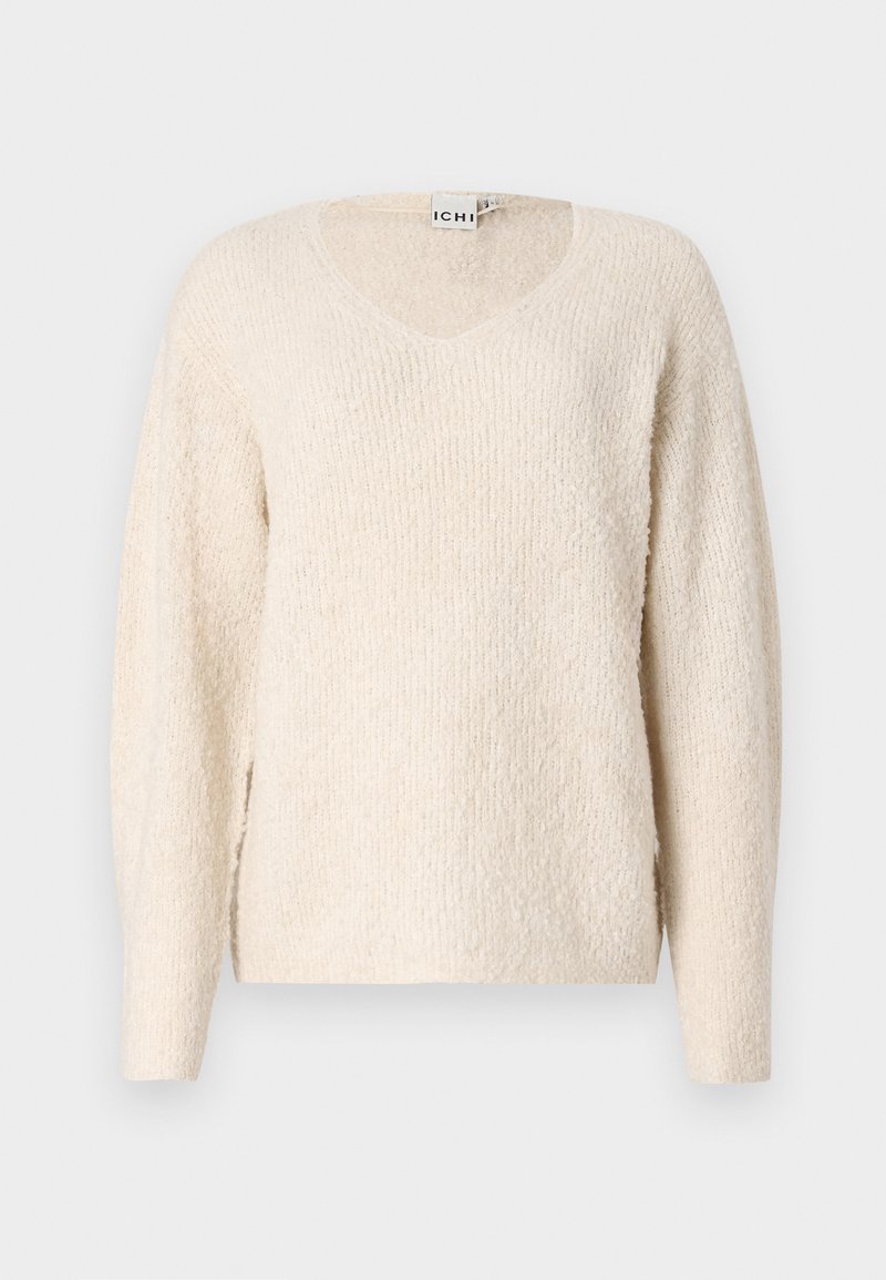 Licht beige sweater van zacht, textuurstof. Beschikt over een V-hals, lange mouwen en zijsplitten voor comfort. Eenvoudig, minimalistisch ontwerp.