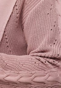 Neulepaita pehmeässä vaaleanpunaisessa, jossa on yhdistelmä tekstuureja, ribatut yksityiskohdat ja löysä, mukava istuvuus.