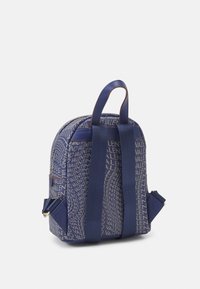 Mochila azul marino con una tela texturizada que presenta un patrón de logotipos repetido. Tiene correas ajustables y un compartimento principal con cremallera.