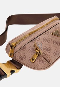 Brun stof crossbody tas med en tekstureret overflade, guld lynlåse og et trekantet logo. Har en justerbar chokoladebrun rem.