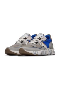 Scarpe sportive con una combinazione di suede grigio, accenti in tessuto blu e lacci bianchi. Presentano una stampa audace sulla suola e elementi di design stratificati.