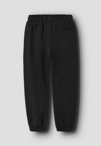 Pantaloni jogger neri realizzati in tessuto morbido, con vita elastica, fondo aderente e tasca posteriore. Texture liscia senza motivi.