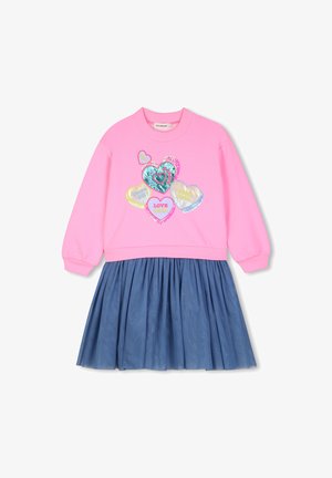 Pink langærmet top med farverige hjerte-patches og blå glitrende plisseret nederdel fastgjort, der danner en kjole til et barn.