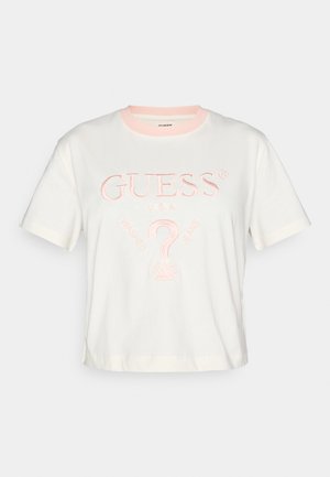Hvid t-shirt med korte ærmer og en lyserød krave, med broderet "GUESS®" logo og designelementer for "WASHED JEANS" i lys pink.