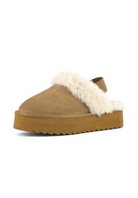 Chaussure slip-on en daim marron avec un bord en fourrure crème duveteuse, présentant une semelle épaisse et texturée de couleur beige et un léger talon.