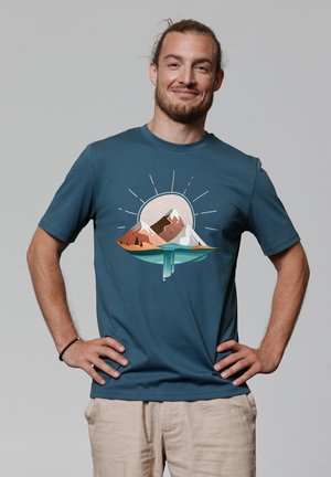 Turquoise katoenen t-shirt met een grafisch ontwerp van bergen en een zon. Korte mouwen, ronde hals, normale pasvorm.