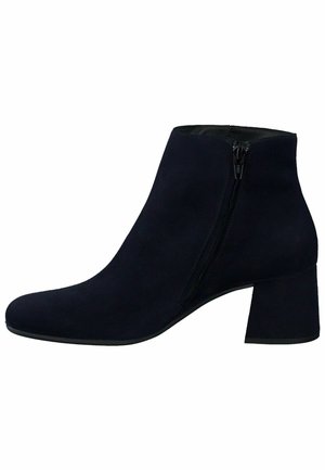 Bottes chevilles en suède bleu marine avec un talon carré et une fermeture éclair latérale. Texture lisse, bout pointu et design minimaliste.