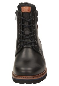 Schwarze Lederstiefel mit Fellfutter, blauen Akzent-Schnürsenkeln, braun gestickter Sohle und einem rechteckigen braunen Lederpatch am Schaft.