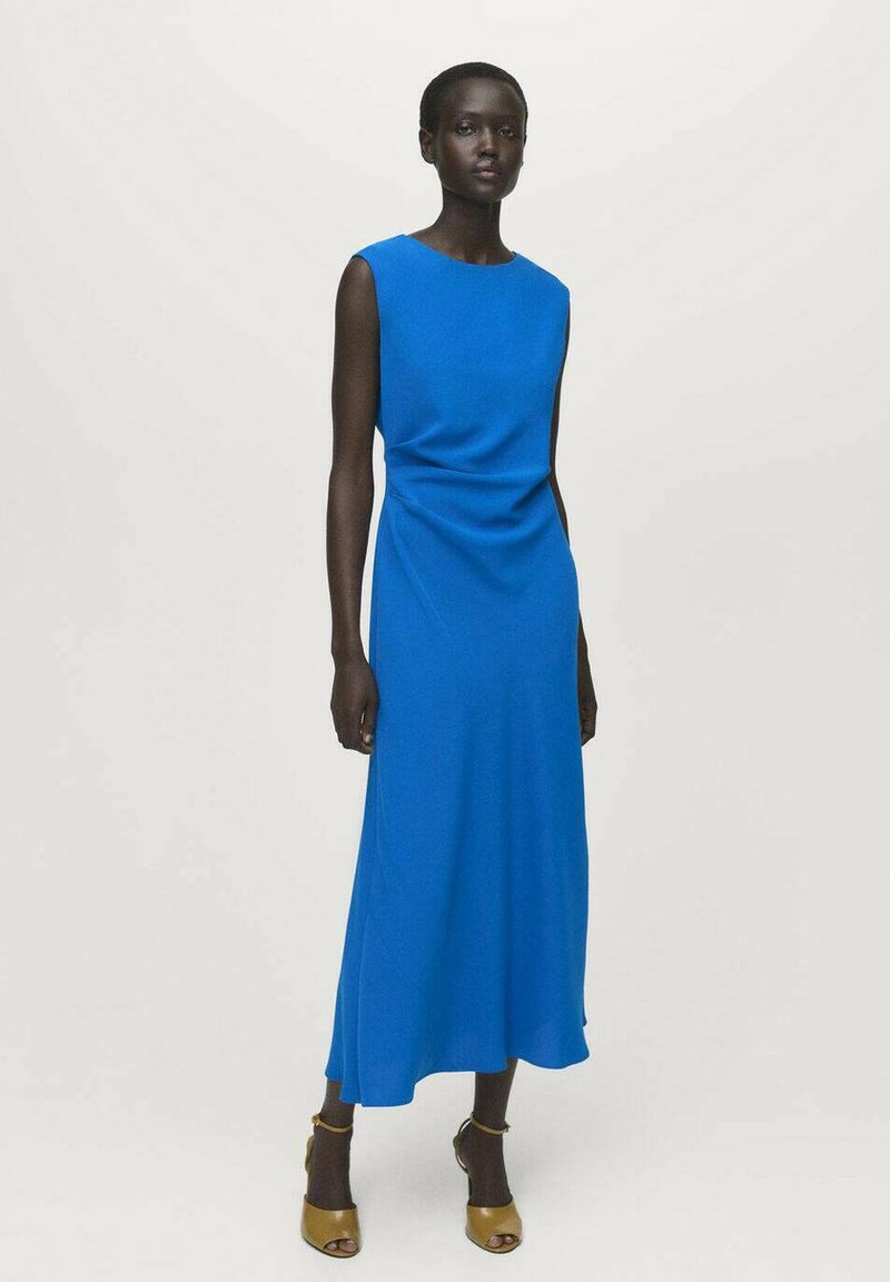 Vestido maxi sin mangas de color azul con escote redondo, textura suave y detalles fruncidos en el costado, combinado con zapatos marrones de tiras en el tobillo.
