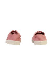 Een paar versleten roze canvas sneakers met witte rubberen zolen, van achter bekeken op een witte achtergrond.