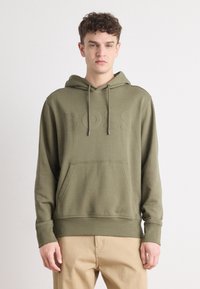 Felpa con cappuccio verde oliva, logo "BOSS" tono su tono, tasca frontale e accessori in metallo argentato per il cordino. Tessuto morbido con polsini a coste.