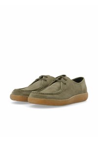 Zapatos de ante verde con puntera redondeada, detalles de costura y una suela de goma marrón texturizada. Cierres con cordones y un diseño de perfil bajo.