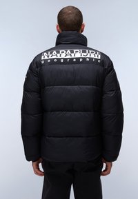 Svart puffjacka med hög krage, med stor vit logotext på baksidan, quiltade sektioner och ribbade muddar.