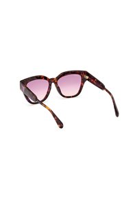 Gafas de sol de carey marrón con forma de ojo de gato, lentes en degradado púrpura y herrajes de metal dorado en las patillas.