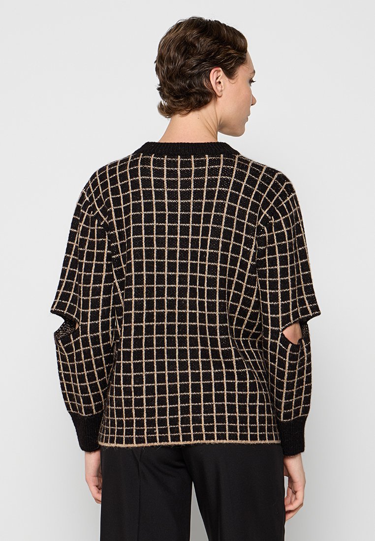 Schwarz-beige kariertes Sweatshirt mit Rundhalsausschnitt, lockerer Passform, weiten Ärmeln und Ausschnitten an den Seiten. Strukturiertes Strickmaterial.