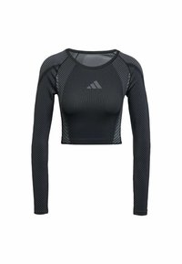 Crop top nero a maniche lunghe realizzato in tessuto elastico, presenta un design aderente, motivi testurizzati e un logo sul petto. Accenti a righe sulle maniche.