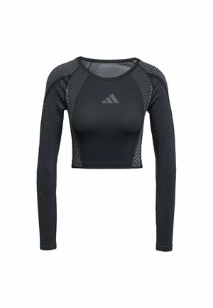 Black long-sleeve crop top made from stretch fabric features a fitted design, textured patterns, and a logo on the chest. Striped accents on sleeves.