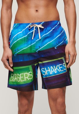 I pantaloni da bagno colorati presentano una stampa vivace con tonalità di blu, verde e nero, che mette in evidenza un testo in stile neon che recita "BURGERS" e "SHAKES."