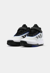 Atletická obuv v bílé a černé barvě s modrými akcenty. Síťovinový svršek, uzavírání na pásek, gumová podrážka s texturovaným vzorem.