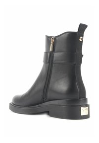 Botine negre, realizate din piele netedă, cu fermoar pe lateral, accente elastice și talpă din cauciuc texturat. Detaliu din aur pe toc.