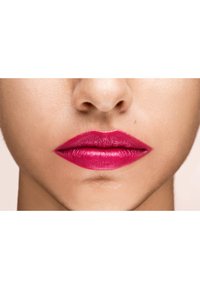 Ljusröd matt läppstift applicerat jämnt på fylliga läppar, vilket visar en jämn textur och definierad form mot den naturliga hudtonen.