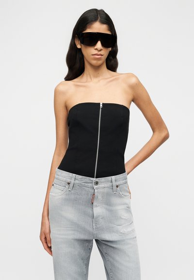 Μαύρο τοπ μπαντέο με φερμουάρ στο μπροστινό μέρος. Συνδυασμένο με ανοιχτό γκρι τζιν με φθορές, διαθέτοντας σχέδιο με πέντε τσέπες και κλασική εφαρμογή.