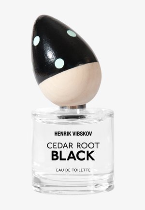 Klart glass parfymeflaske med svart og tredeksel, med mintfargede prikker. Etiketten leser "Henrik Vibskov Cedar Root Black Eau de Toilette."