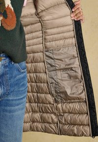 Čierna prešívaná bunda s lesklou béžovou podšívkou, so zipsom a štítkom Joules. Textúrovaný, ľahký a zateplený dizajn.