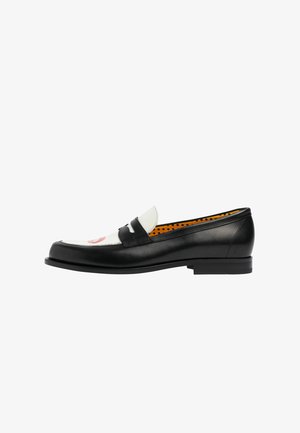 Mocassins en cuir noir avec une tige en tissu blanc et une inscription rouge. Texture lisse, bout arrondi et petit talon carré.