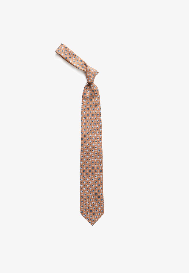 Cravate brun clair avec de petits motifs floraux bleus et blancs, nouée en un nœud lâche sur fond blanc.