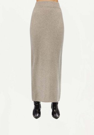 Jupe midi grise à côtes avec une taille haute, texture lisse et silhouette ajustée, associée à des bottines noires.