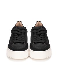Zapatillas negras texturizadas con cordones planos negros, que presentan una suela de goma blanca y un ligero acolchado en el tobillo.
