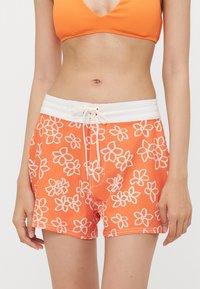 Oranje zwembroek met wit bloemenpatroon, elastische tailleband en een voorste trekkoord. Gemaakt van lichtgewicht, snel drogend materiaal.
