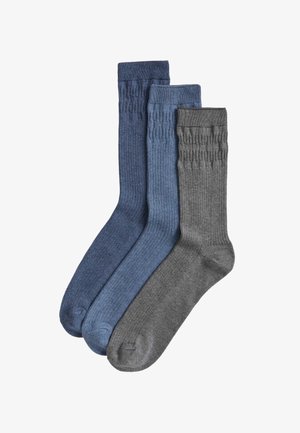 Drei Socken in Dunkelblau, Mittelblau und Grau mit einer gerippten Struktur und einem einfarbigen Design. Jede Socke hat eine mittlere Länge.
