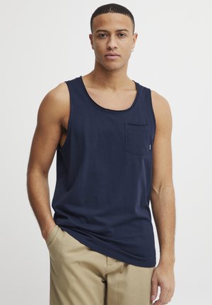 Débardeur bleu marine en matériau doux avec une poche sur la poitrine gauche et une coupe décontractée. Design uni, sans motifs ni accents.