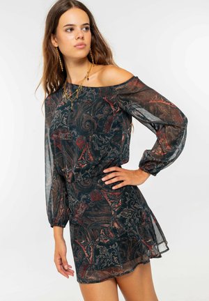 Vestido fluido, con off-the-shoulder en azul oscuro con intrincados patrones de paisley en rojo y oro, tejido transparente y mangas largas y abullonadas.