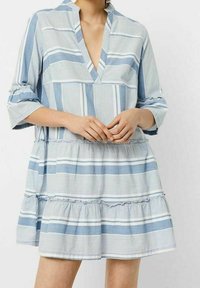 Vaaleansininen ja valkoinen raidallinen mekko, jossa on V-pääntie, kolmannes hihasta ja kerroksellinen röyhelöhelma; puuvillakangasta, rento malli.