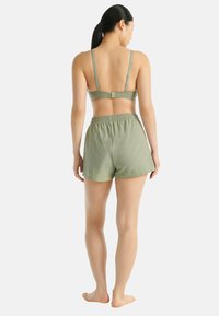 Zelená měkká tkaninová braletka s nastavovacími ramínky a odpovídajícími šortkami s elastickým pasem. Hladká textura, lehká, pohodlný design a jednoduchost.