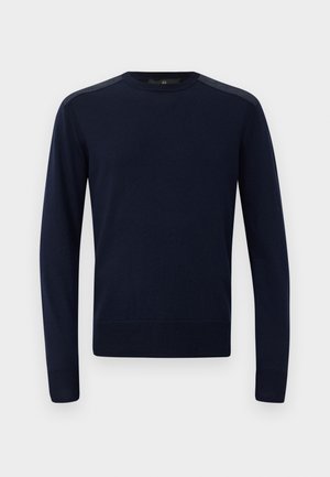 Suéter de punto azul marino con mangas largas, cuello redondo y puños acanalados. Presenta acentos texturizados en los hombros y una silueta ajustada.