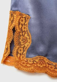 Il tessuto di raso blu presenta una squisita bordatura in pizzo arancione con motivi floreali lungo l'orlo, evidenziando dettagli intricati e texture.