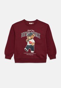Sudadera burdeos con un gráfico de un oso con una gorra de béisbol y camisa, con el texto "NUEVA YORK" y una cita impresa debajo. Textura suave, diseño casual.