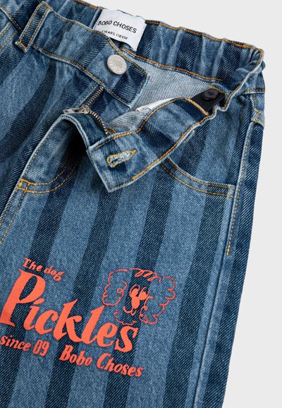 Jean rayé bleu pour enfants avec un motif de chien orange "Pickles" et le logo "Bobo Choses", avec bouton, fermeture éclair et ceinture ajustable visibles.