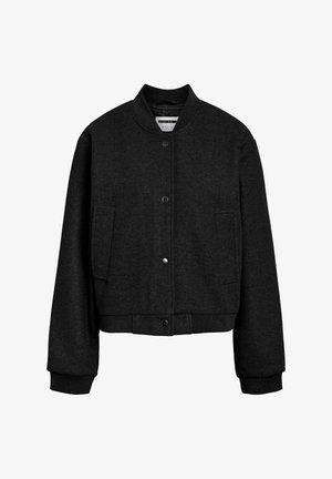 Svart bomberjakke i ull med ribbestrikket krage, mansjetter og kant, trykknappglidelås foran og to sidelommer, vist mot hvit bakgrunn.