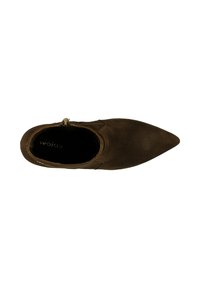 Botte de cheville en suede marron avec un bout pointu et une fermeture éclair sur le côté. Elle présente une texture lisse et une doublure intérieure sombre.